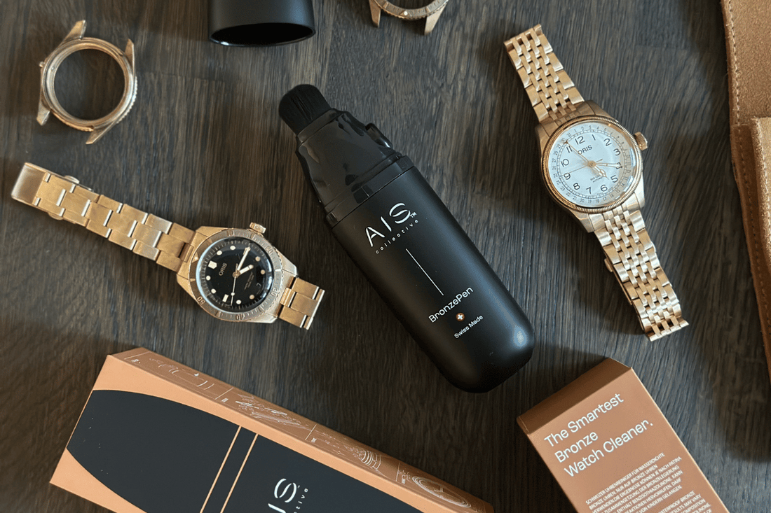 AIS Collective BronzePen Swiss Made per la pulizia di orologi Oris in bronzo, con orologi e bracciali Oris esposti e confezione.