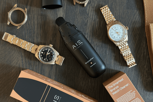 AIS Collective BronzePen Swiss Made per la pulizia di orologi Oris in bronzo, con orologi e bracciali Oris esposti e confezione.
